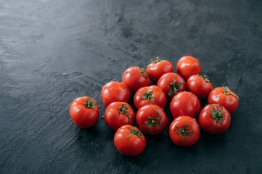 Kırmızı olgun sebzeler yağmurdan sonra ıslaşıyor. Koyu arka planda hasat domates. Lezzetli organik yiyecekler. Vegeterian ürünleri. Domates olgunlaşma