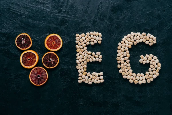 Cartas de comida. Garbanzo y rebanada de cítricos en forma de letras de verduras sobre fondo oscuro. Ingredientes orgánicos para vegetarianos. Productos saludables —  Fotos de Stock