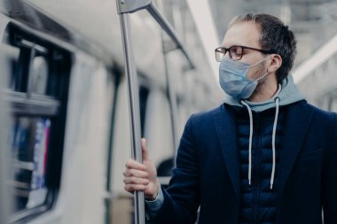 Hasta adam tıbbi maskeden nefes alıyor, toplu taşıma araçlarıyla seyahat ediyor, koronavirüs veya gripten koruyor, yeraltında çalışıyor, gözlük takıyor ve kapüşonlu giyiyor. Salgın hastalık konsepti