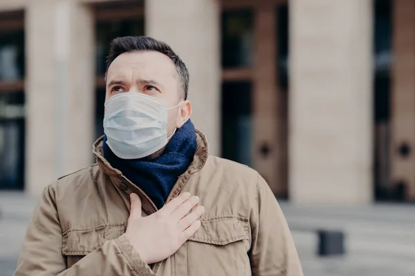 Hasta adamın açık havada çekilmiş görüntüleri, virüslere karşı tıbbi maske takıyor, nefes darlığı çekiyor ve öksürüyor, kendini iyi hissetmiyor, koronavirüsten koruyor, sağlığına önem veriyor, yukarılara bakıyor. Salgın durumu