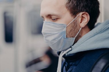 Ciddi bir adamın kalabalık yerlerde dolaşması, yer altında işe gidip gelmesi, salgın ve koronavirüs enfeksiyonu sırasında yüz koruması için maske takması. Hastalık Koruma Konsepti