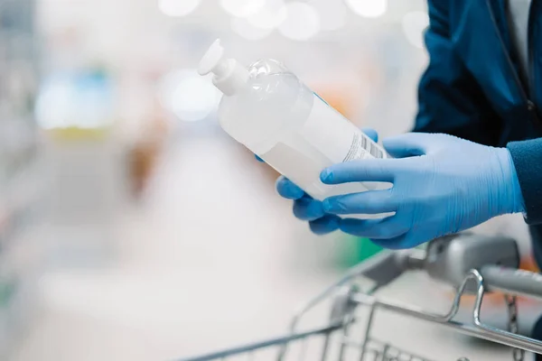 Persona Irreconocible Guantes Médicos Sostiene Botella Gel Desinfectante Posa Tienda —  Fotos de Stock