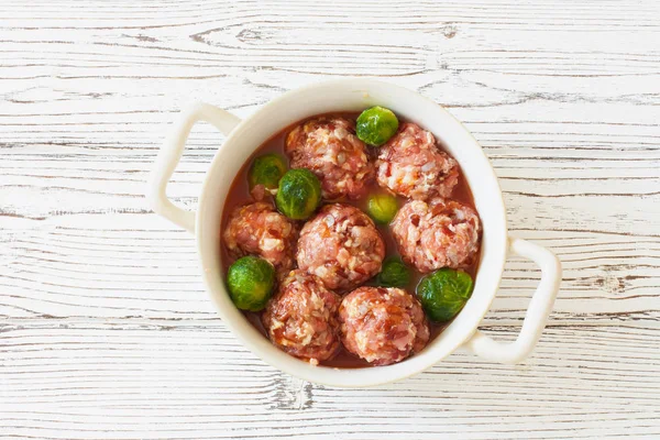 Raw meatballs and brussel sprouts — Stock Photo, Image