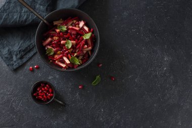 Siyah bir tabakta pancar, elma ve kırmızı fasulye vegan salatası yakın plan. Düz yatıyordu. Boşluğu kopyala