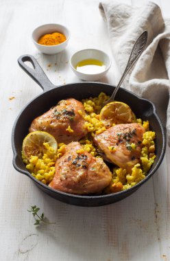 Demir tavada pilav ve nohut ile kızarmış tavuk butları. Seçici odak