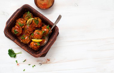 Beyaz ahşap bir masada domates soslu köfteler. Düz yatıyordu. Boşluğu kopyala