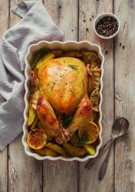 Patates ve limonla kızartılmış tavuk ve ahşap bir arka planda pişirme tepsisi. Düz yatıyordu. Boşluğu kopyala