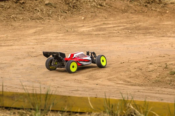 Modelo de carro controlado por rádio em corrida na pista de terra — Fotografia de Stock