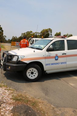 Bicheno, Avustralya - 6 Ocak 2013: Coles Bay yolundaki Polis ve Devlet Acil Servisi. İtfaiyeciler yolu kapatıp yangınları kontrol altına almaya çalışıyor. Tazmanya. Avusturalya