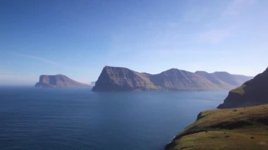 Kallur deniz feneri yürüyüş alanı mavi gökyüzü ile güneşli bir günde Kunoy ve Vidoy adalarını gösteriyor.