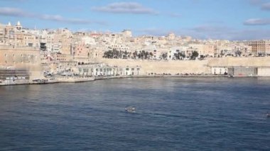 Mavi gökyüzü ile güneşli bir günde üç şehirden Valletta 'ya geçen tekneler, Malta
