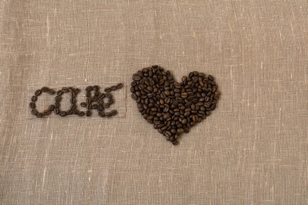 Grãos de café torrados, linho, a palavra café em francês, café, cartão, em espanhol, coração , — Fotografia de Stock