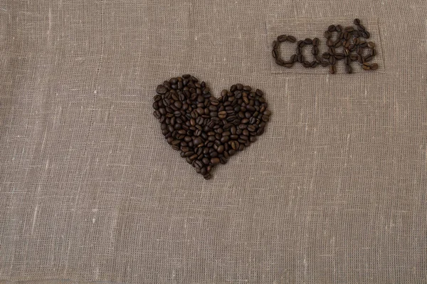 Grains de café torréfiés, lin, le mot café en carte de café italienne, en italien, coeur , — Photo