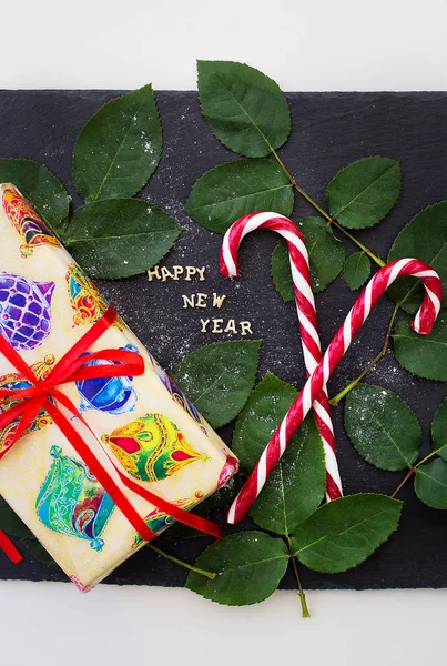 Напис нового року на чорній дошці з подарунком та червоними цукерками — стокове фото