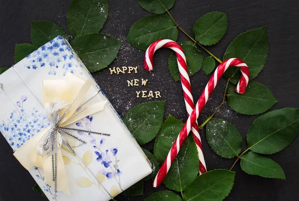 Напис нового року на чорній дошці з подарунком та червоними цукерками — стокове фото