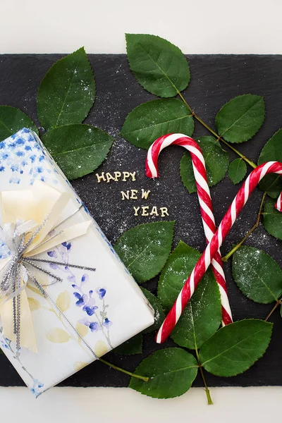 Напис нового року на чорній дошці з гарним подарунком і червоними цукерками — стокове фото