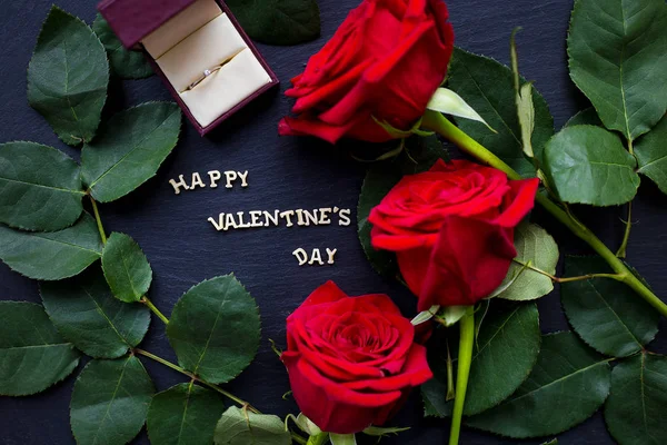 The inscription "Happy Valentine" on a black background with red roses and wedding ring — Stock Photo, Image