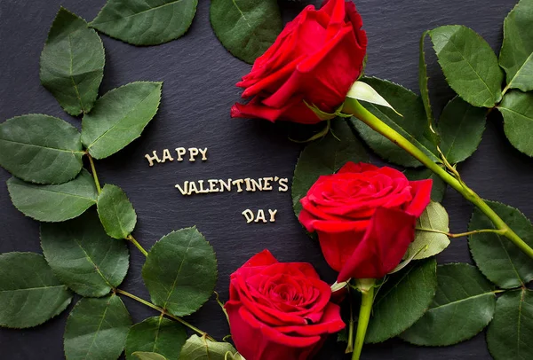 La inscripción "Feliz Valentín" sobre un fondo negro con rosas rojas — Foto de Stock