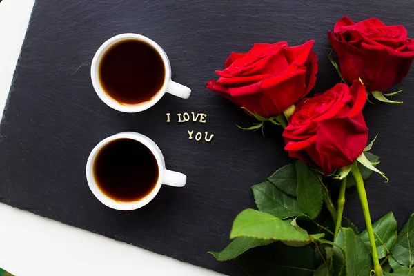 La inscripción "Te amo" sobre un fondo negro con rosas rojas — Foto de Stock
