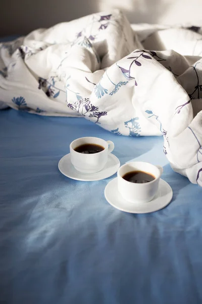 Dos tazas de café en la cama, luz del sol —  Fotos de Stock