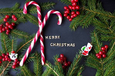 Ağaçların dalları ile siyah arka plan üzerine şeker. Mutlu Noeller yazıt