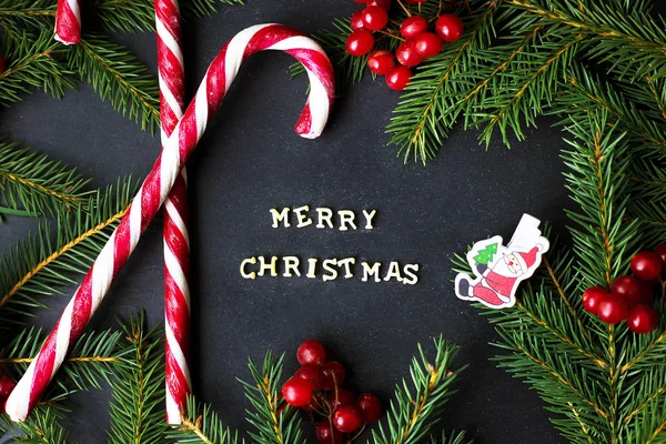 木の枝と黒の背景のお菓子します。碑文のメリー クリスマス — ストック写真