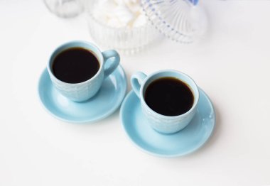 İki kahve fincanı tablo ve marshmallow ile fincan tabağı üzerinde mavi