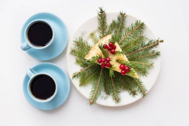 Noel ağaç dalları ve çilek Noel ağacının bir arka plan ve iki bardak kahve kek dekore edilmiştir
