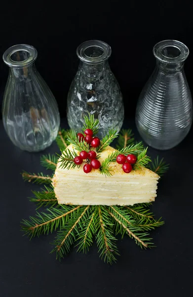 Piece of cake decorated tree and berries on a black background with vases — Stock Photo, Image