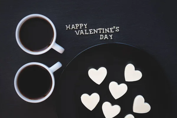 Дві чашки кави та шоколаду цукерки з білим формі серця - напис щасливого Валентина, Закри — стокове фото