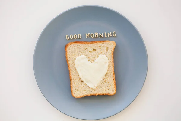 Sanduíche de café da manhã na forma de coração com queijo em uma inscrição de chapa azul bom dia — Fotografia de Stock