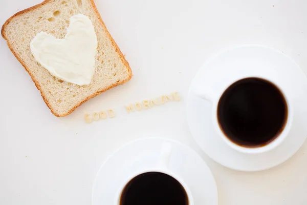 Kahvaltı için kalp şeklinde peynirli sandviç - günaydın işareti ve iki kahve fincanı