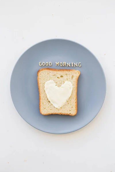 Бутерброд на завтрак в виде сердца с сыром на синей табличке с надписью "Доброе утро" — стоковое фото