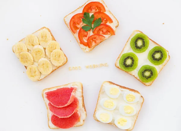 Яркая смесь сэндвичей на завтрак, надпись с добрым утром — стоковое фото