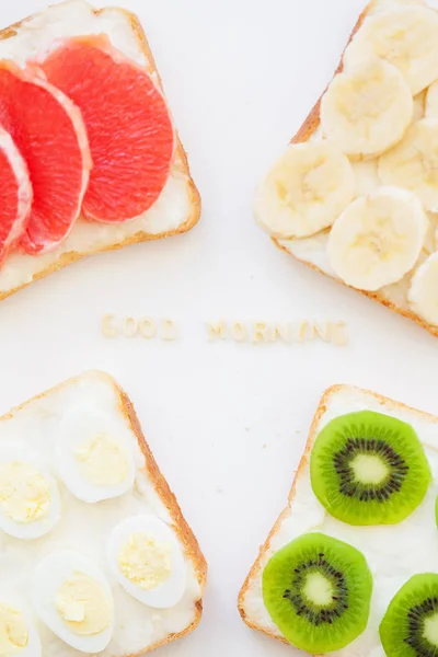 Brillante mezcla de sándwiches para el desayuno (frutas, verduras, pescado, huevos) inscripción buenos días — Foto de Stock