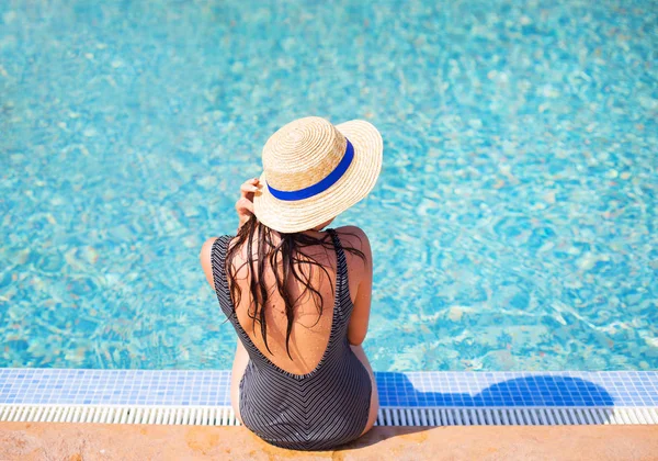 Mavi bir havuz yakınındaki bir siyah mayo güzel kız.