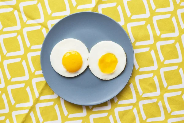 Two eggs on a plate and a yellow napkin. — Stock Photo, Image