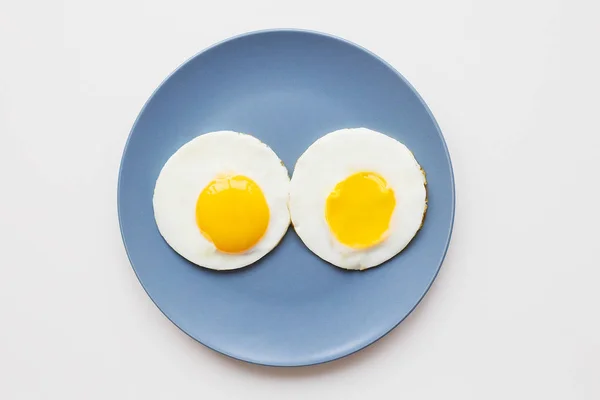 Two beautiful eggs on a plate and a yellow napkin. — Stock Photo, Image