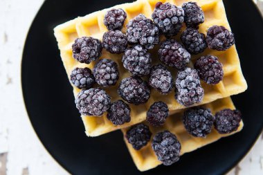 Eski ahşap masa üstünde böğürtlen ile Belçika waffle yakın çekim