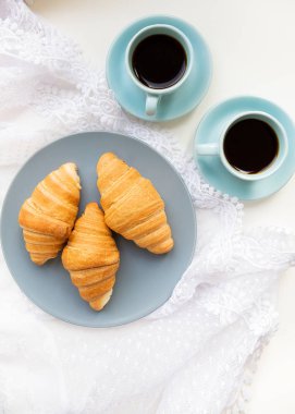 Bir fincan kruvasanla kahve.