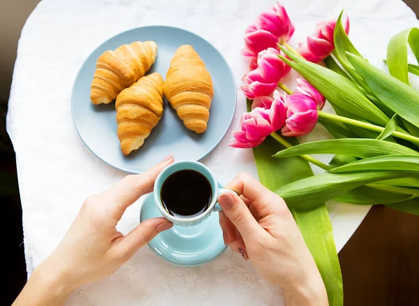 Girl with croissants and coffee, a bouquet of pink tulips, happy morning — Stock Photo, Image