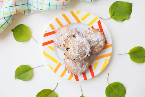 Színes cupcakes egy tányérra, zöld levelek és törölköző — Stock Fotó