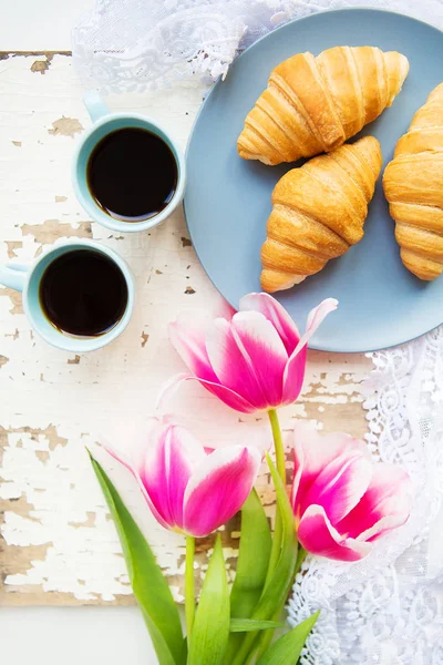 Coffee, croissants and three beautiful pink tulips on old white table — Stock Photo, Image