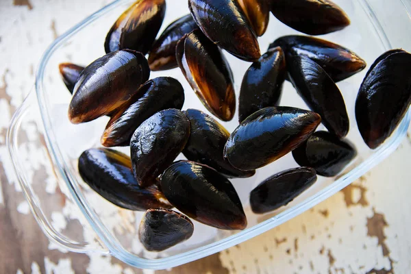 Eski ahşap beyaz masa taze midye.