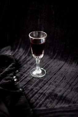 Kadife siyah bir zemin üzerine kırmızı şarap güzel bir bardak
