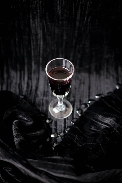 Copa de vino tinto sobre un fondo de terciopelo negro, primer plano — Foto de Stock