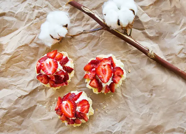 Schöner Muffin mit frischen Erdbeeren liegt auf Bastelpapier, Nahaufnahme — Stockfoto