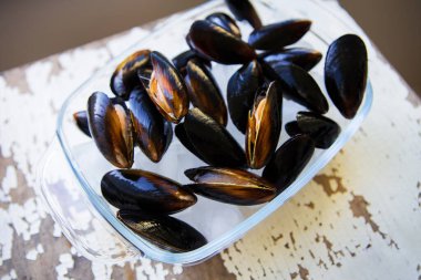 Eski ahşap beyaz masa taze midye.