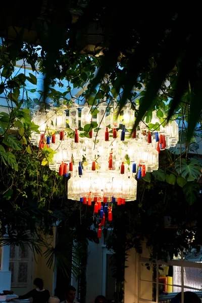 A beautiful chandelier surrounded by green — Stock Photo, Image