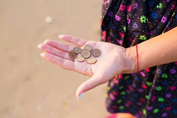 Girl holds coins to throw in sea — Stock Photo, Image